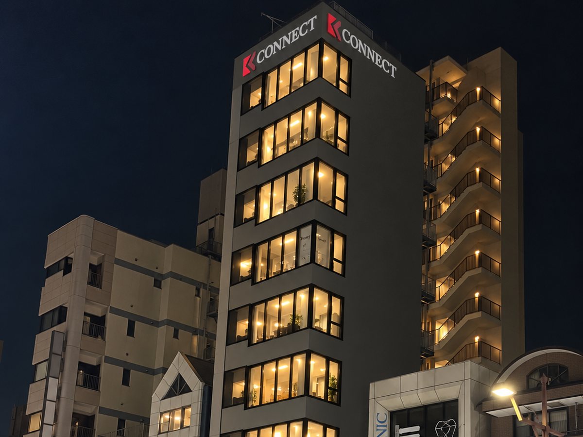 夜、屋上にCONNECTの看板が灯る東京本社のビル外観